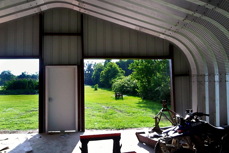 Inside view of A-Model Quonset hut with Yamaha motorcycle inside
