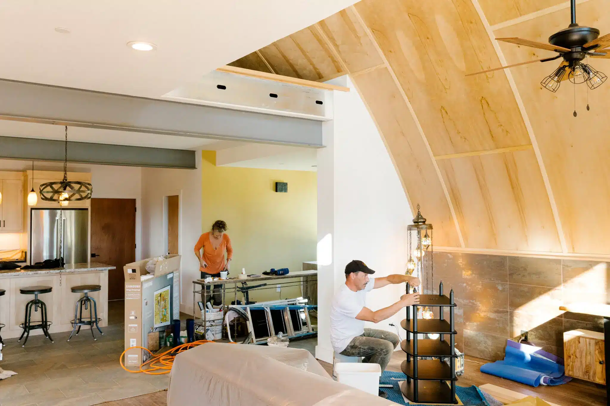 two people working inside of custom quonset hut home