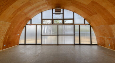 Interior of Q-Model Quonset hut with wood roof and clear end wall