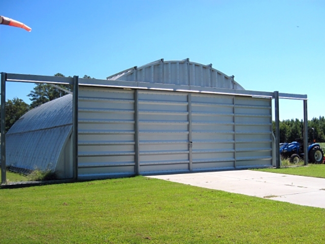 q model steel ag storage with steel sliding door and tractor next to it