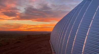 Side of a Quonset hut with sunset view in the background