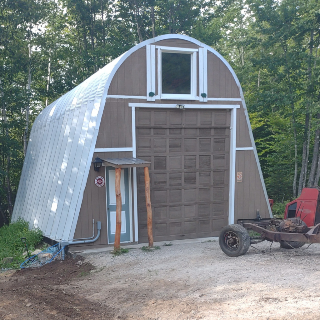 x-model quonset hut with brown endwall, blue front door and brown garage door