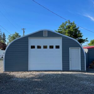 a model custom garage with white garage door and white walk through door with small louver vent on top with blue siding