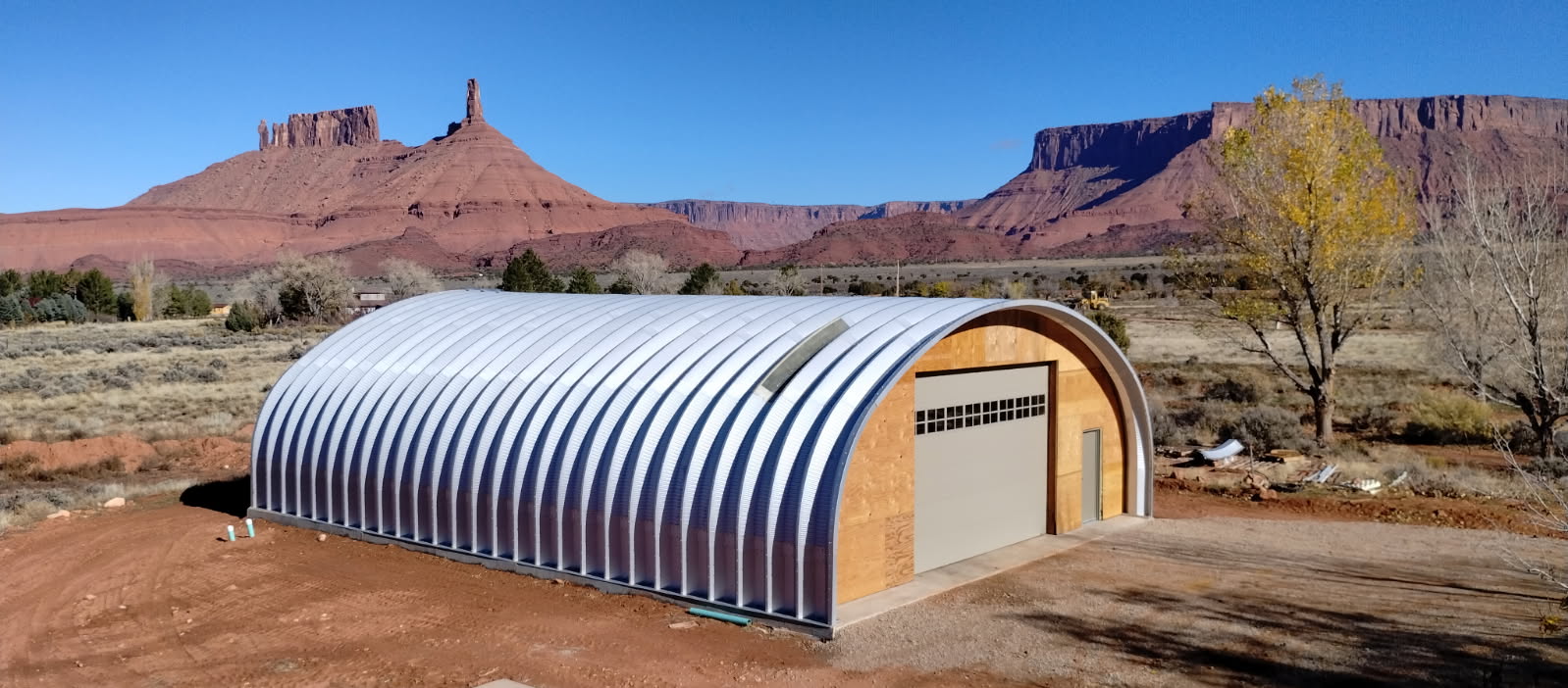 long s model steel garage with custom wood front endwall and garage door with desert mountains in the background